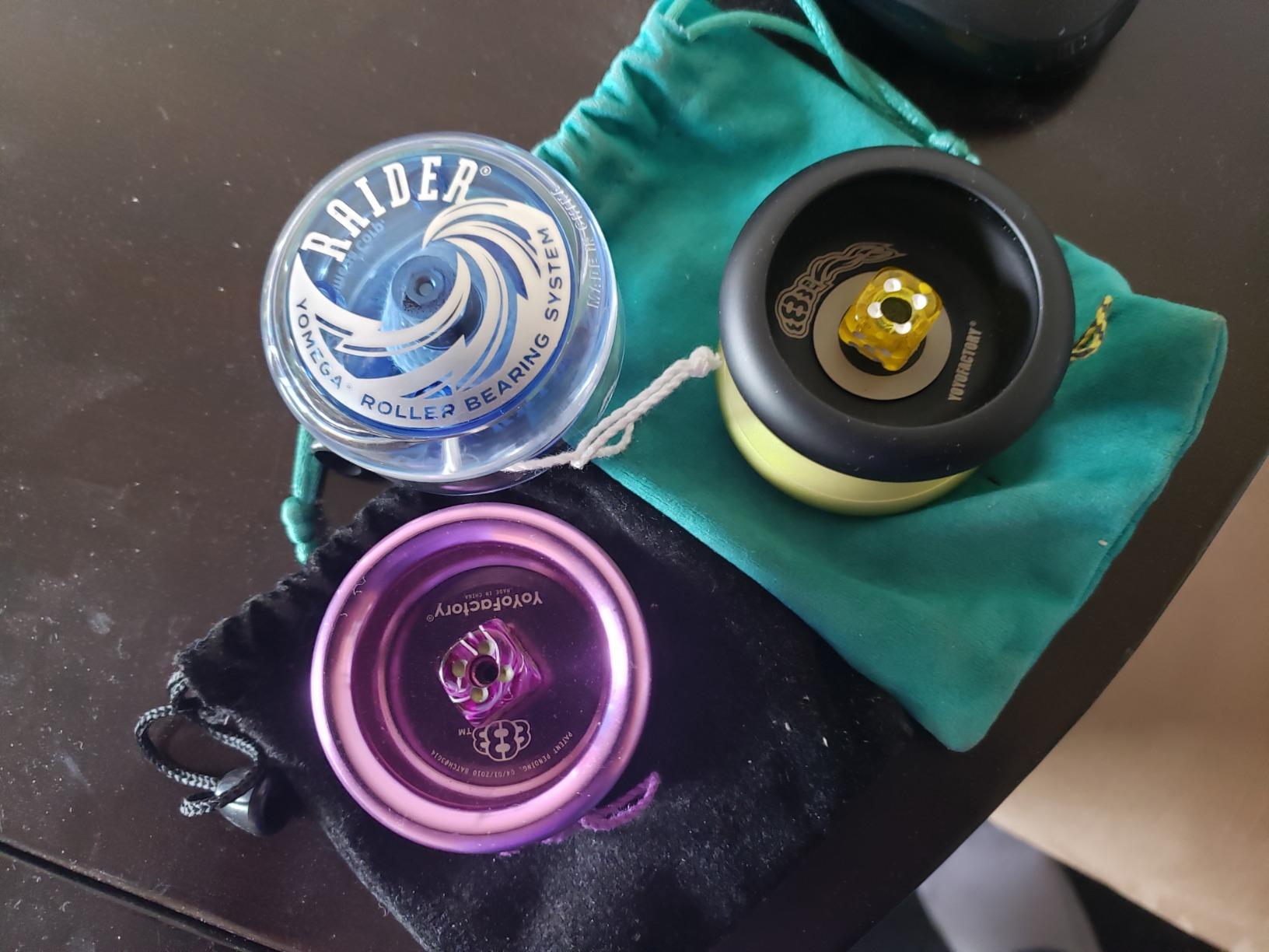 Clear Yomega Raider next to two metal ball-bearing yo-yos