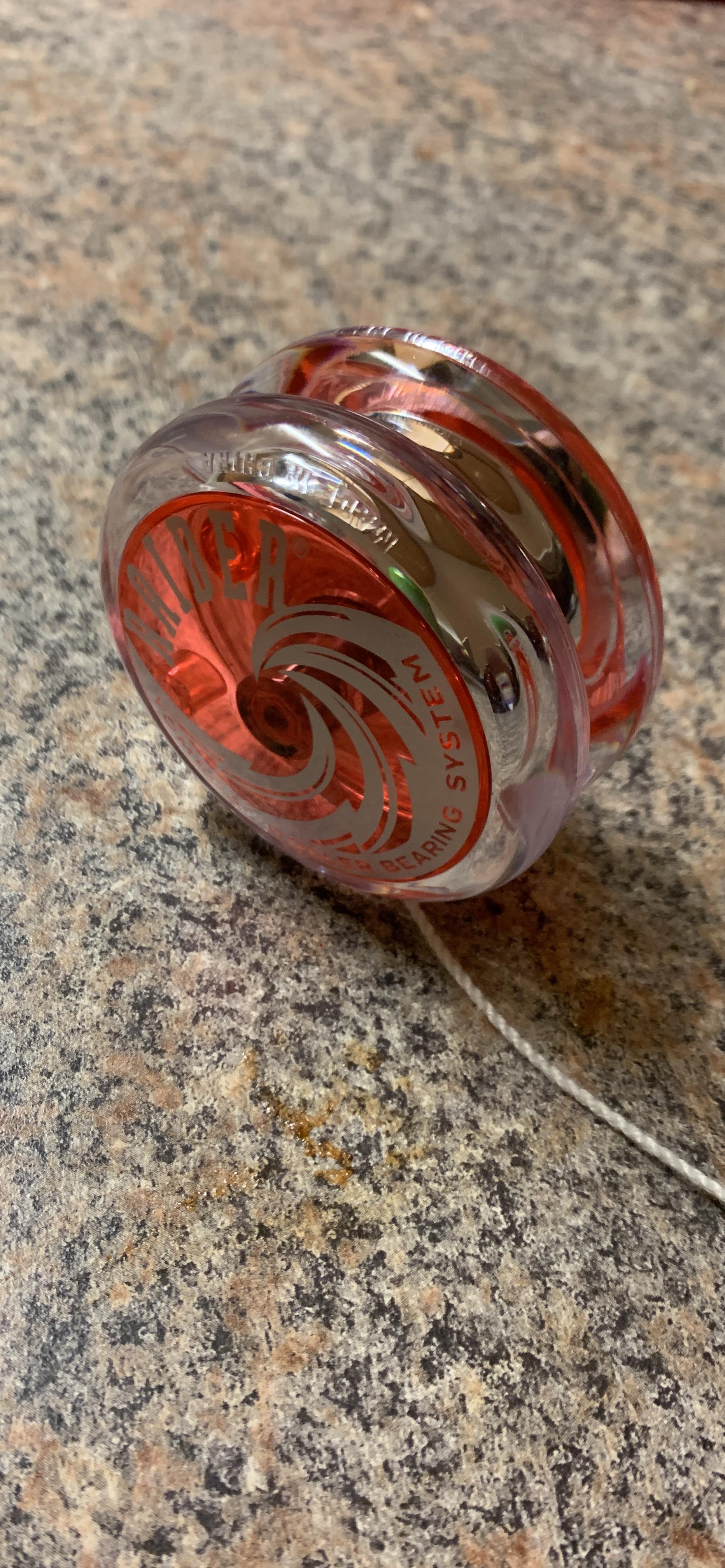 Clear red Yomega yo-yo resting on a kitchen counter